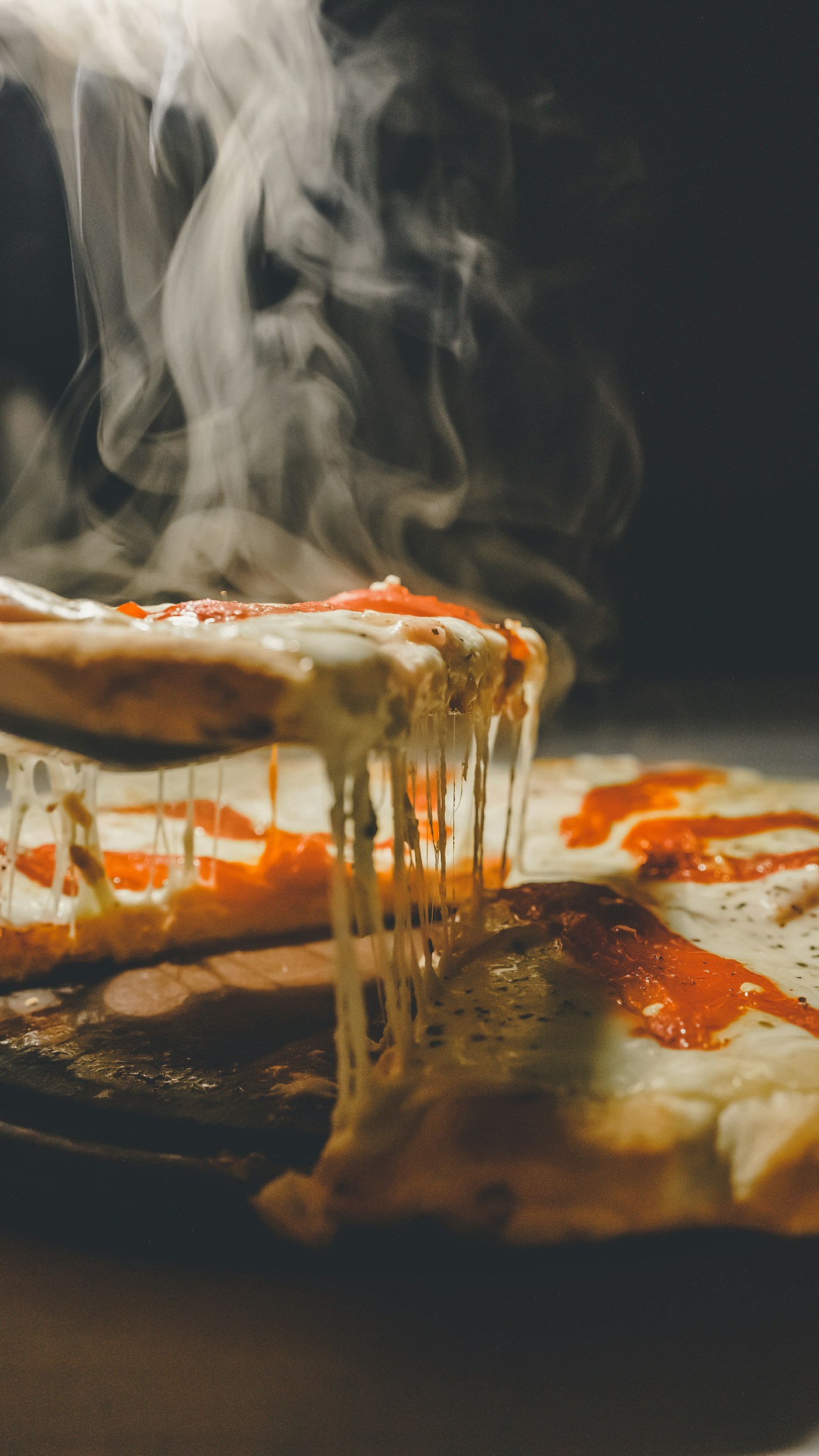 Tranche de pizza fumante au four à bois, mozzarella qui s'étire