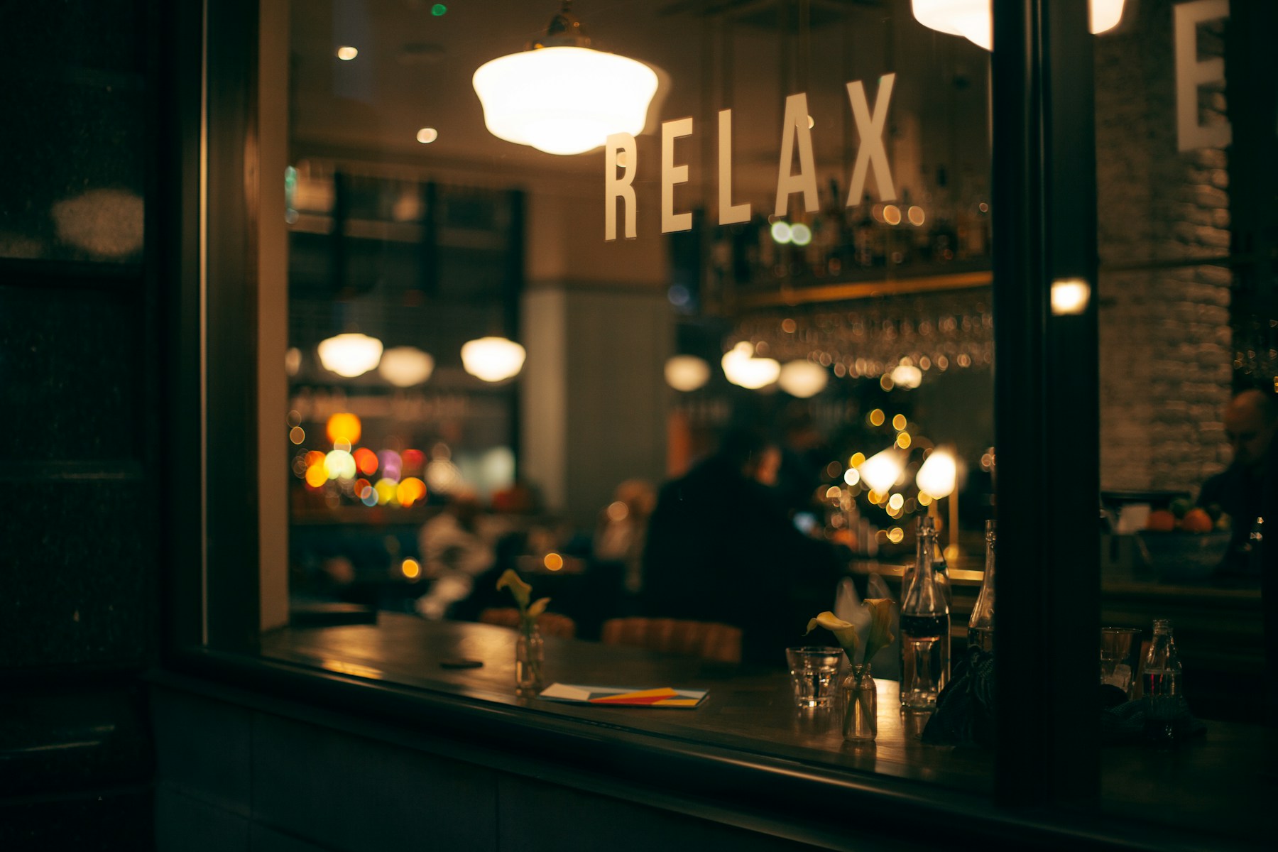 Salle de trattoria en soirée, lampes chaleureuses, bougies